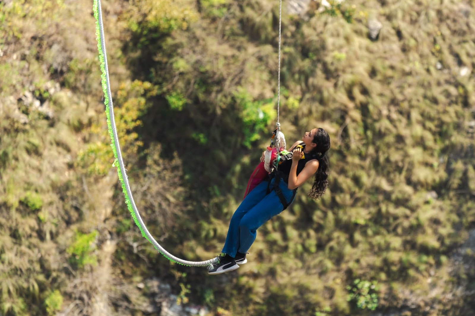 Jumper swinging on the giant bunjee swing above the Ganga gorge at Adventure Island Rishikesh