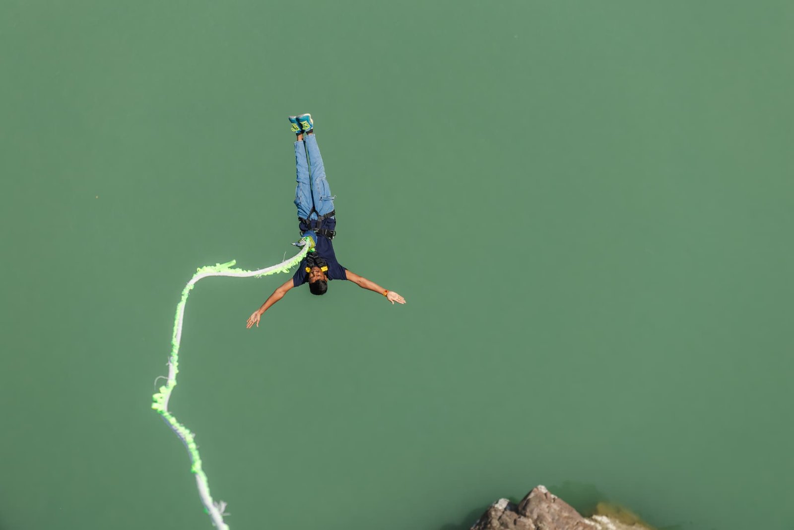 Bungee jumper mid free-fall over the green Ganga valley in Rishikesh