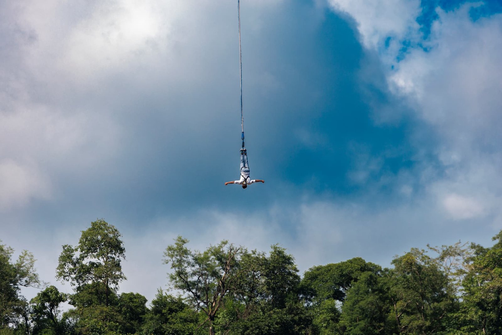 Bungee jumper suspended above the forest canopy and river at Shivpuri, Rishikesh