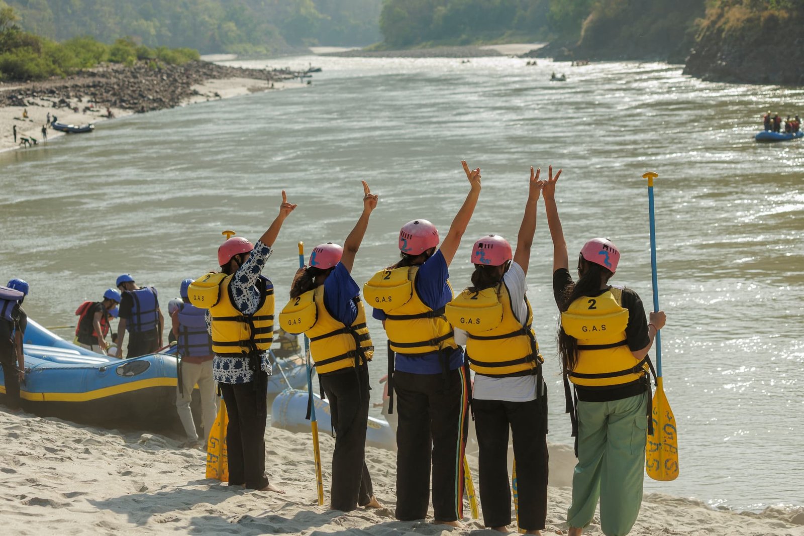 Rafters raising paddles in celebration after finishing a Ganga rafting run