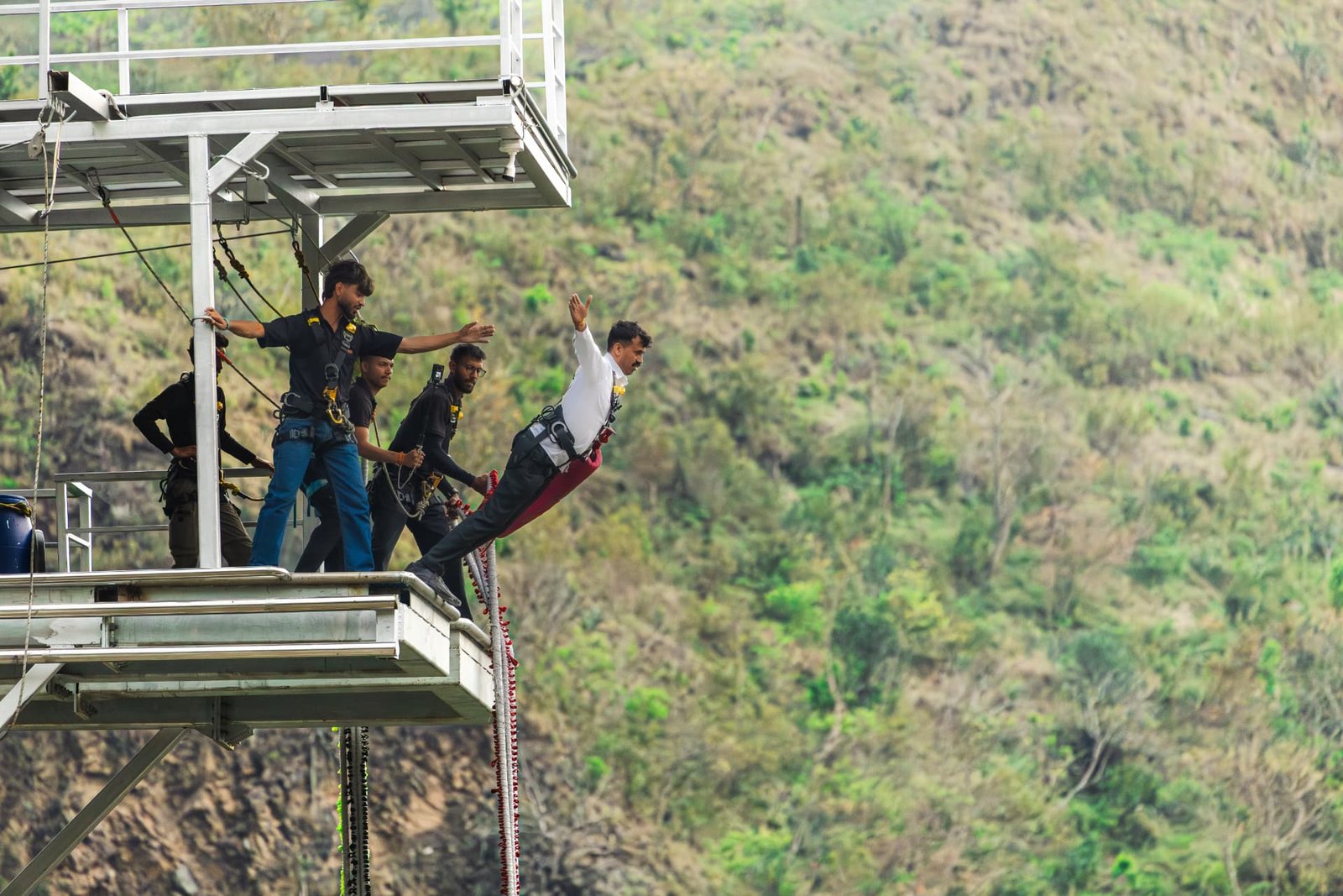 Bungee jumper free falling on the bunjee cord over the Ganga gorge in Rishikesh