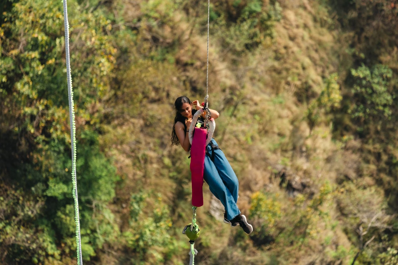 Bungee jumper on the cord rebound above the Ganga gorge at Adventure Island Rishikesh